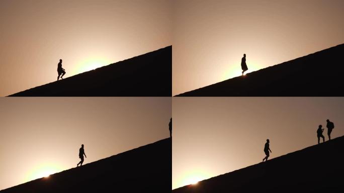纳米布-瑙克鲁夫特国家公园背景下的朝阳在沙丘上行走的男性游客的4k视图