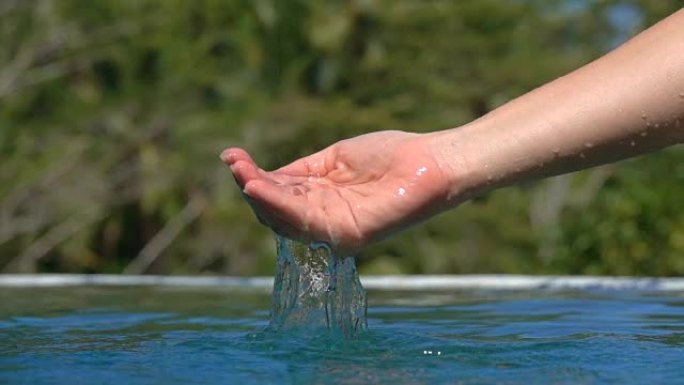 手玩水的慢动作细节，水滴掉进水池