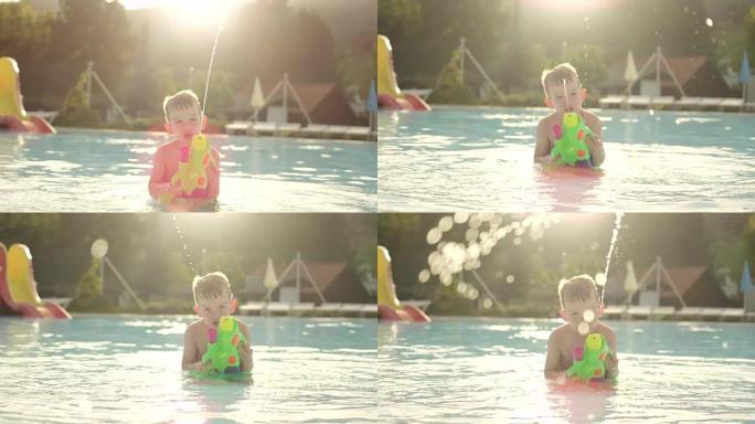 慢动作: 快乐的孩子在有趣的水上公园美丽的金色夏日日落时，用水枪将水滴直接喷入相机