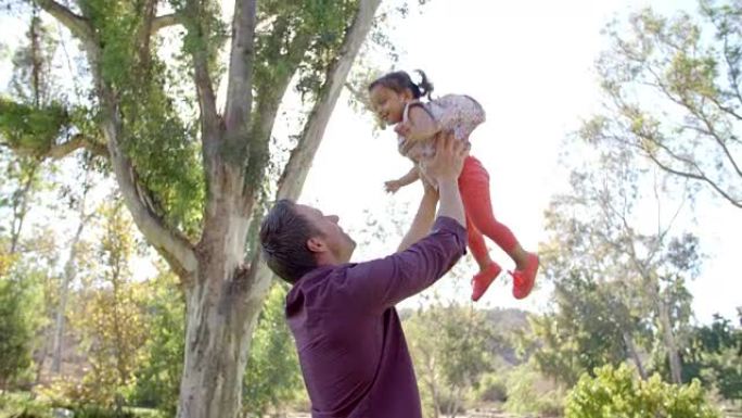 父亲把他的小女儿扔在公园的空中