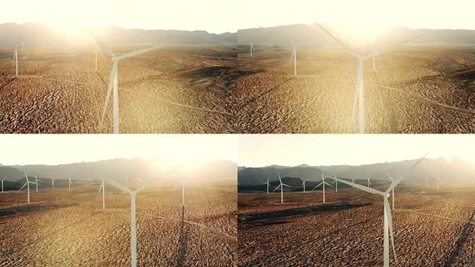 日落时带有透镜耀斑的沙漠中孤立的风车涡轮机的鸟瞰图