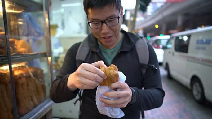 男人吃油煎糕点，香港街头小吃。