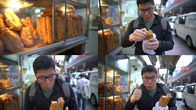 男人吃油煎糕点，香港街头小吃。