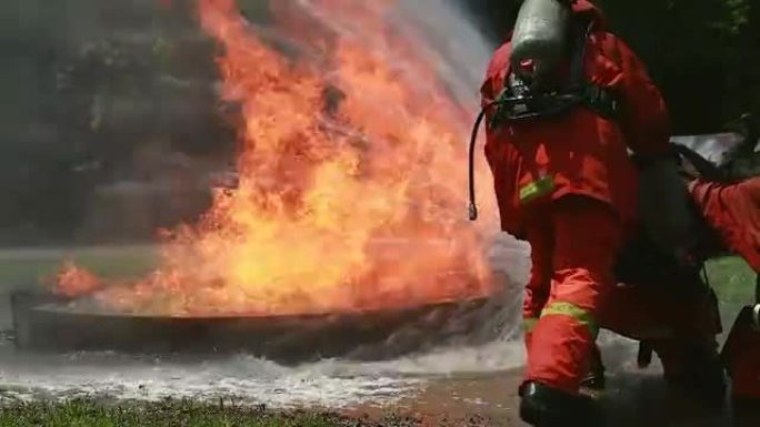 消防员使用灭火器和水管中的水进行消防。在危险情况下，消防员穿着消防服以确保安全。