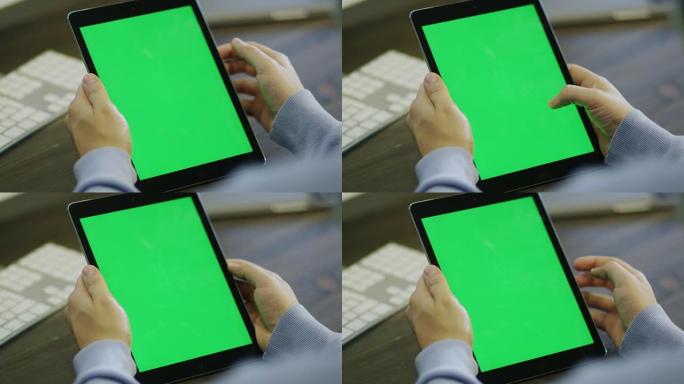 设计师在工作中使用带有绿色屏幕的数字平板电脑。