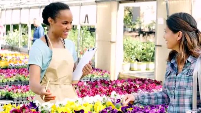 知识渊博的女性花园中心员工帮助女性客户购买