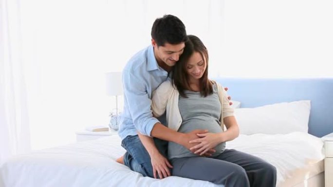 男人拥抱他怀孕的妻子