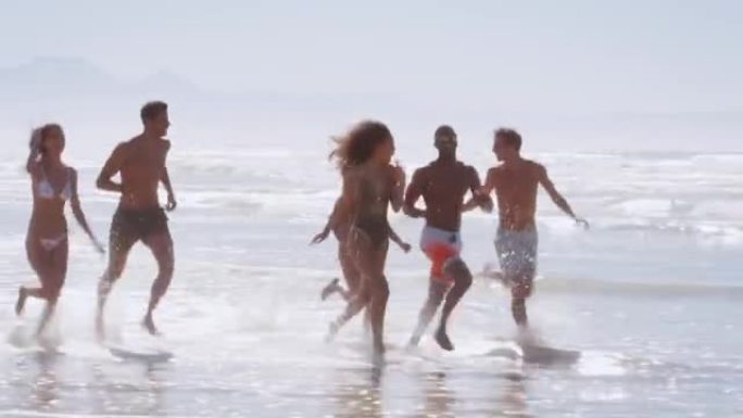 一群朋友在海滩度假中穿越海浪