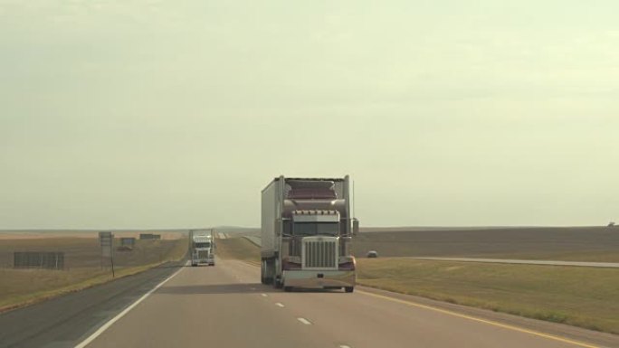 特写: 半卡车在大平原的无尽田野中拖运货物