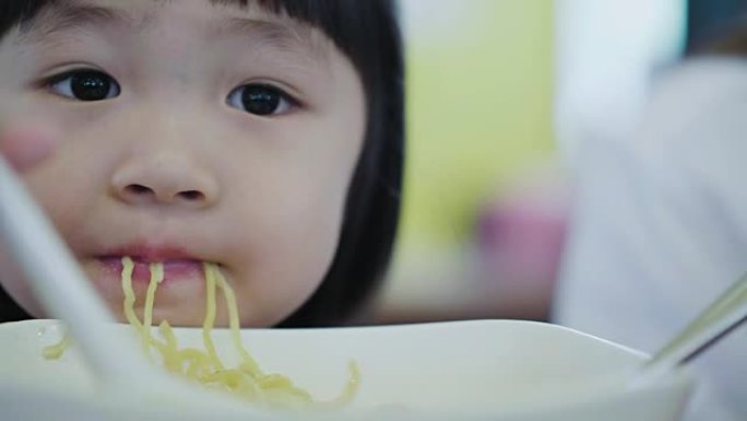 吃面条的亚洲小女孩。