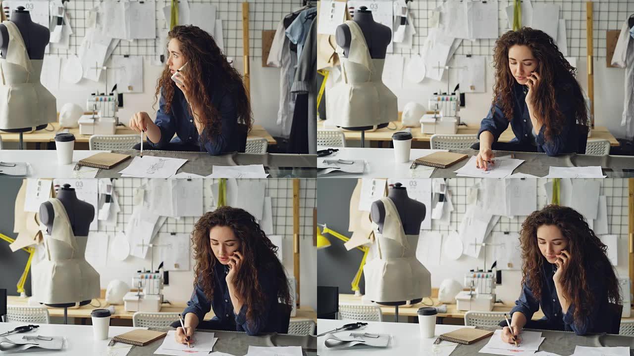 专业时装设计师正在手机上聊天，并在裁缝店的餐桌上用铅笔绘制服装素描。工作场所概念中的日常工作和沟通。