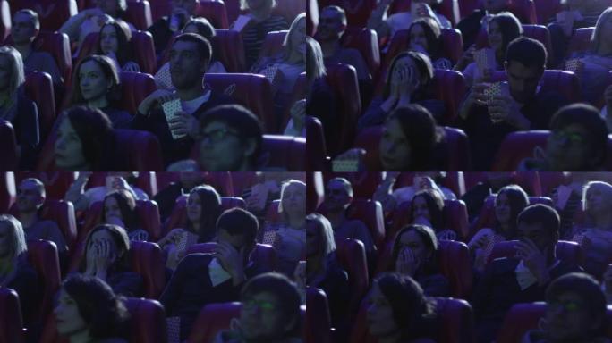 一群人在电影院看恐怖片放映时感到害怕。