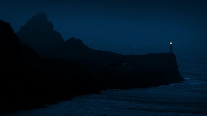 岩石海岸的灯塔在晚上