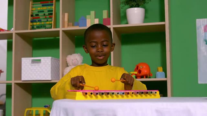 可爱的小男孩在教室里玩木琴