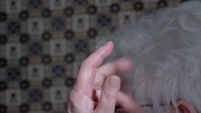 一位正在整理头发的老妇人
