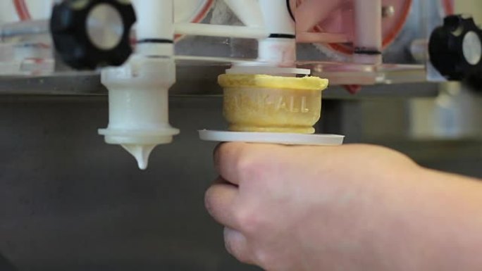 用机器制作扭曲的粉色和白色冰淇淋蛋卷