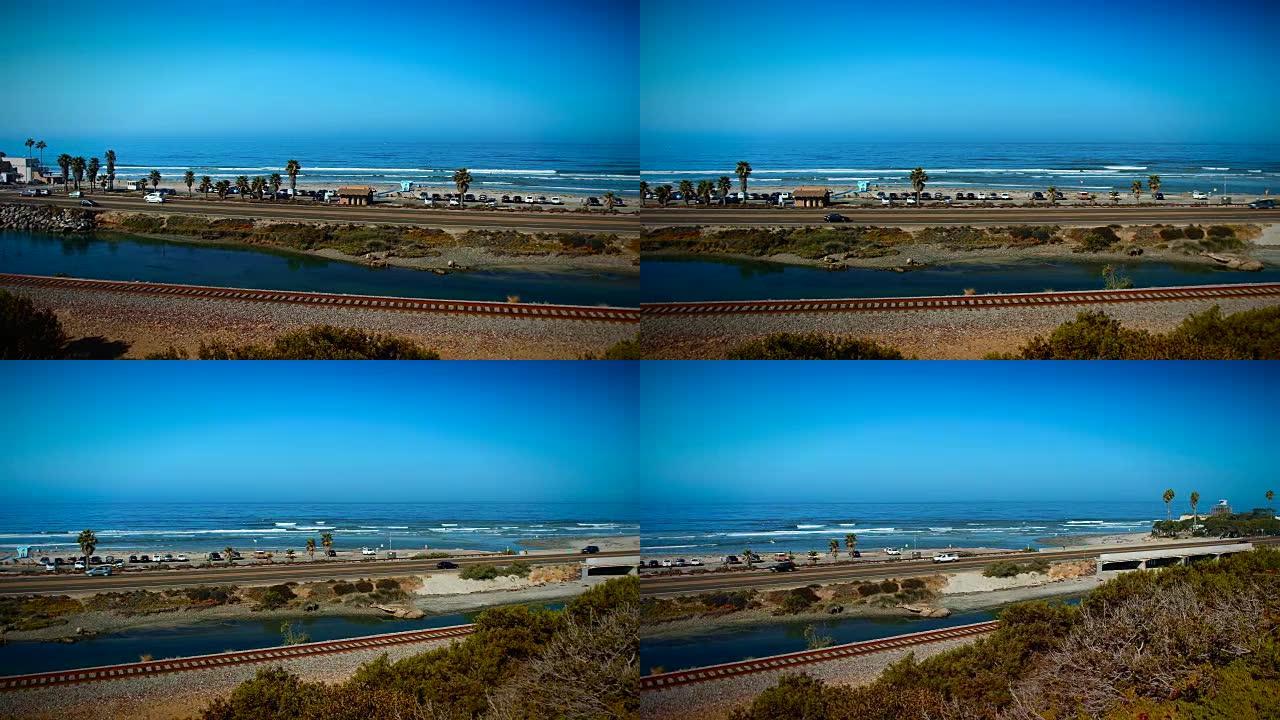 摄像机从左到右平移，展示着著名的冲浪点，加利福尼亚州圣地亚哥的加的夫礁，海浪破裂，冲浪者冲浪。