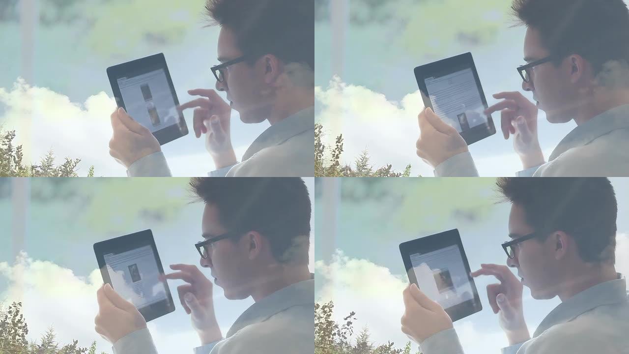 年轻人戴着眼镜使用数码平板电脑，云反射。