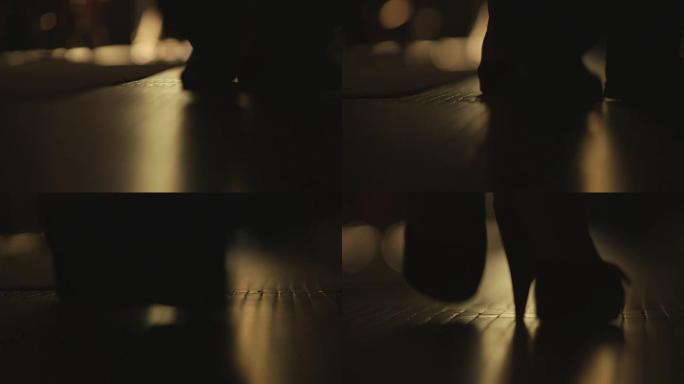 在黑暗中走在地板上的人们的脚的特写剪影