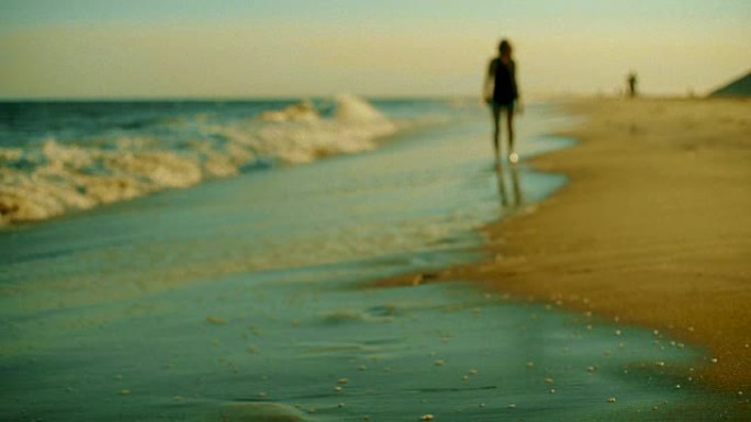 日落时分在沙滩上散步的少女