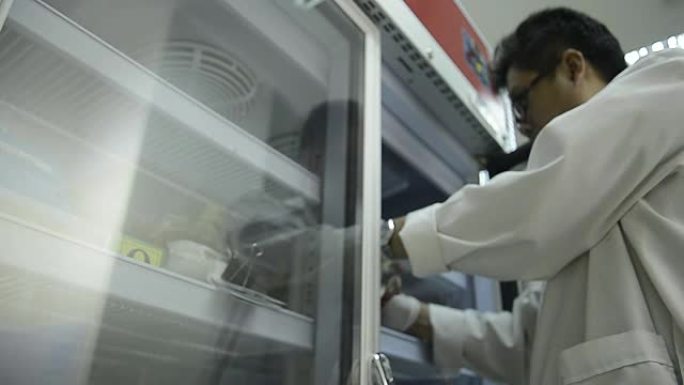 亚洲医疗技术员妇女在实验室医院储存冰箱期间对血袋进行质量控制