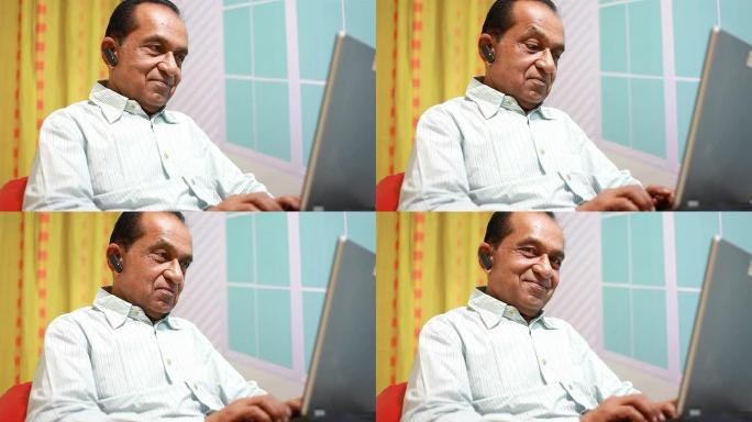 印度老年男子使用笔记本电脑进行视频对话