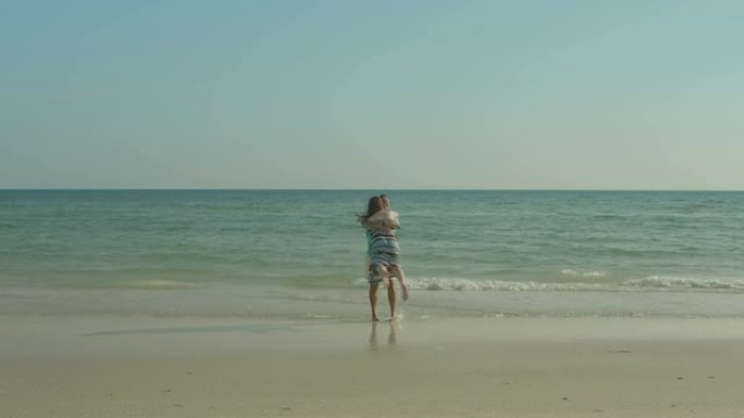一对幸福的情侣在温暖的夏日下午走在海滩上