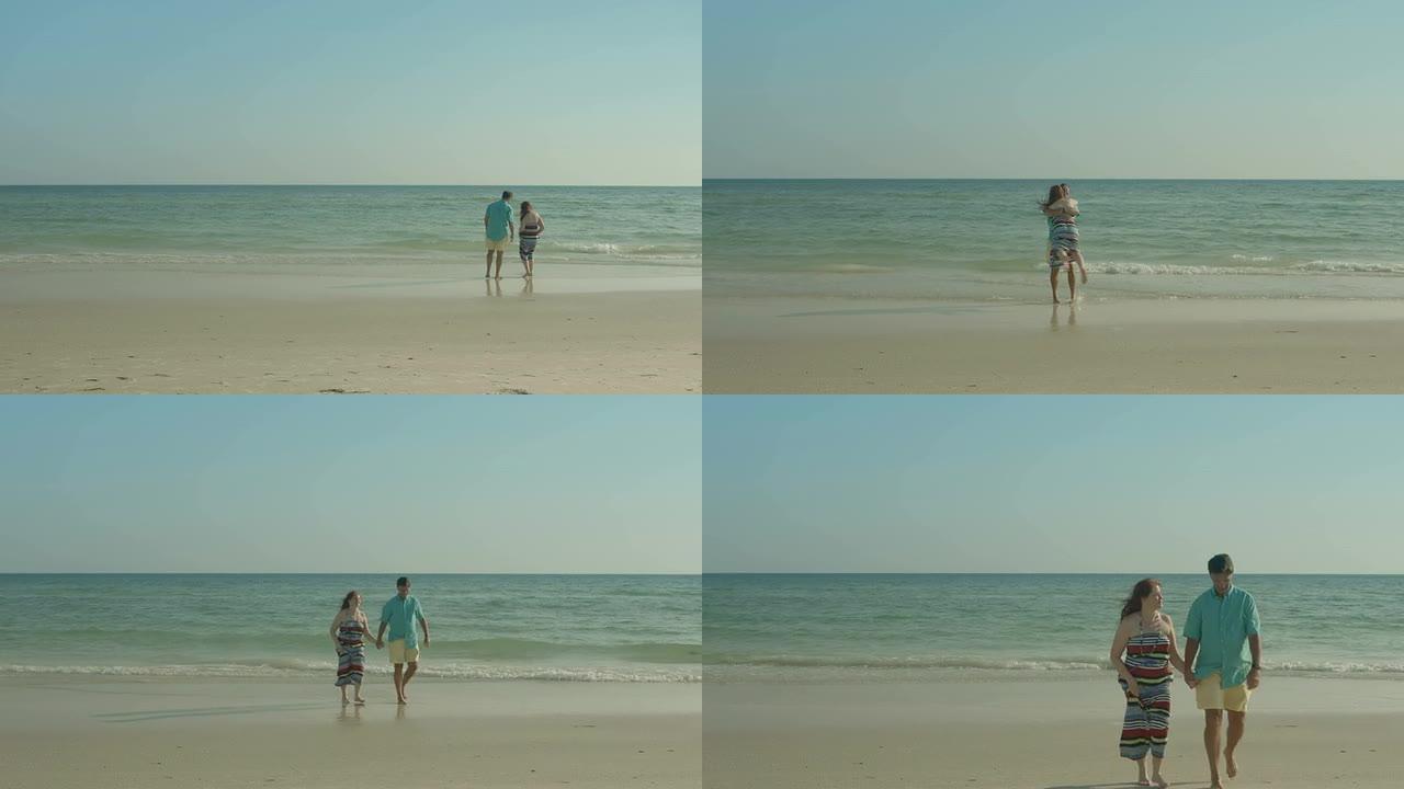 一对幸福的情侣在温暖的夏日下午走在海滩上