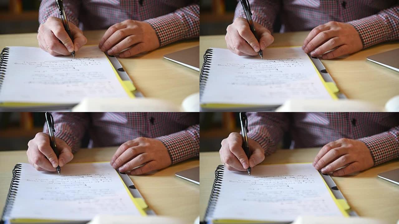 作家的手在纸质笔记本上制作录音笔。