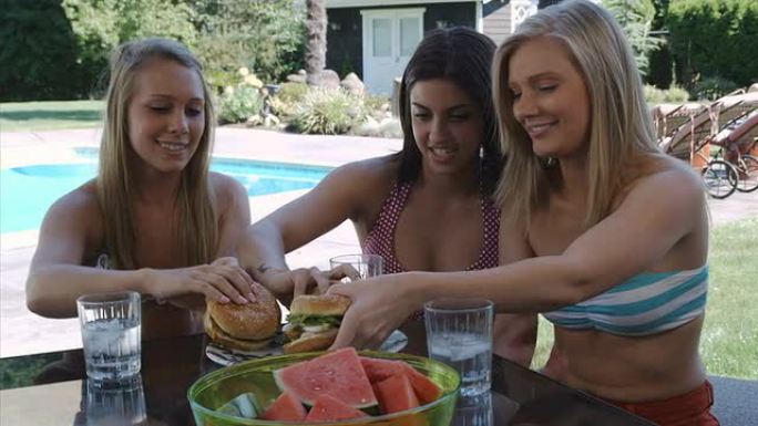 年轻女性在烧烤店吃汉堡