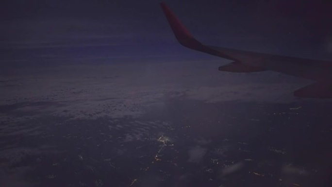 夜城上空的喷气式飞机机翼