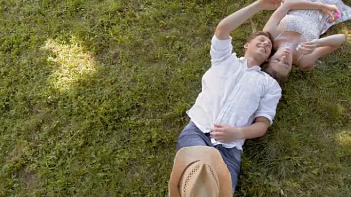 CS年轻夫妇躺在草地上制造泡泡