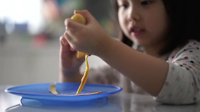 亚洲中国幼儿剥香蕉皮最后吃的特写