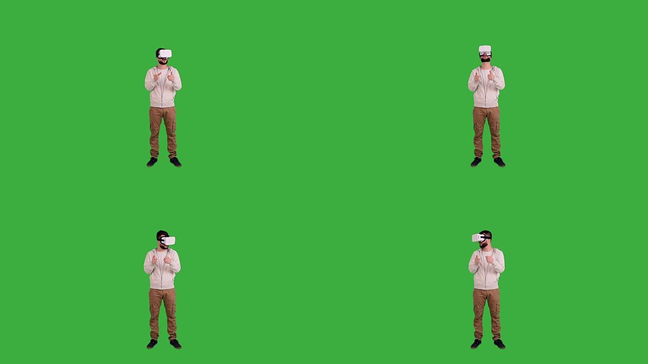 戴眼镜的快乐男人虚拟现实在绿色背景上玩耍