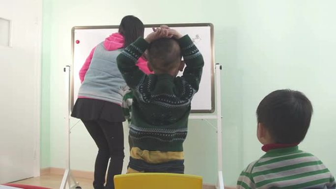 亚洲幼儿教师教孩子在黑板上画画