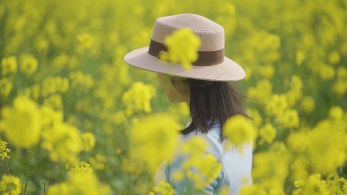 唯美清新美女油菜花林行走背影浪漫亲近自然