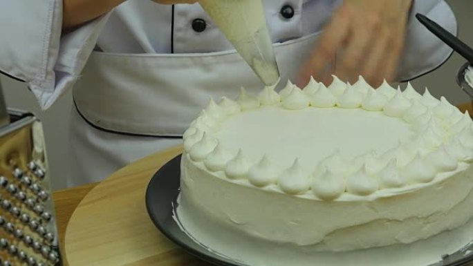 厨师在蛋糕上的滚边奶油