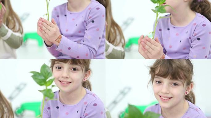 高清：可爱的女孩抱着婴儿植物与地面。