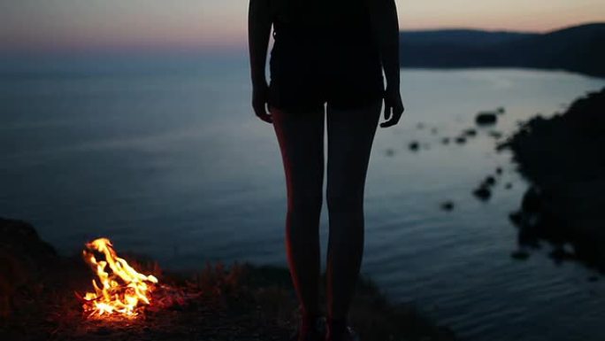 篝火附近的女孩人物剪影湖边篝火燃烧