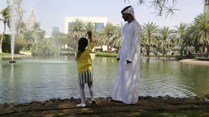 阿拉伯父亲与女儿在湖边野餐