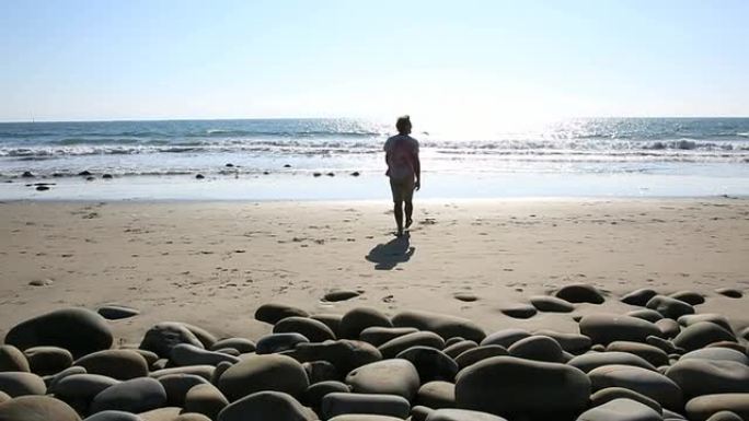 男子走在海岸线岩石上