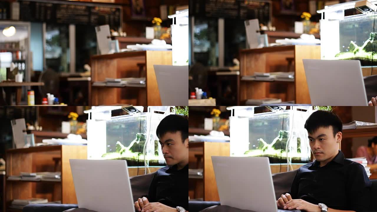 年轻人在咖啡馆相机运动中使用笔记本电脑