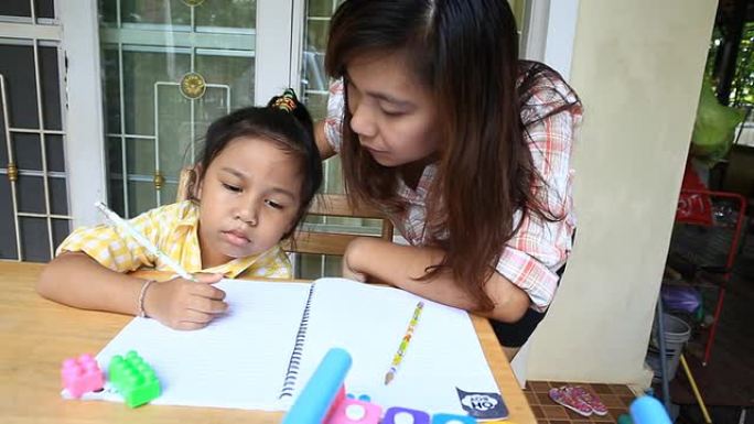 母亲帮助女儿做家庭作业