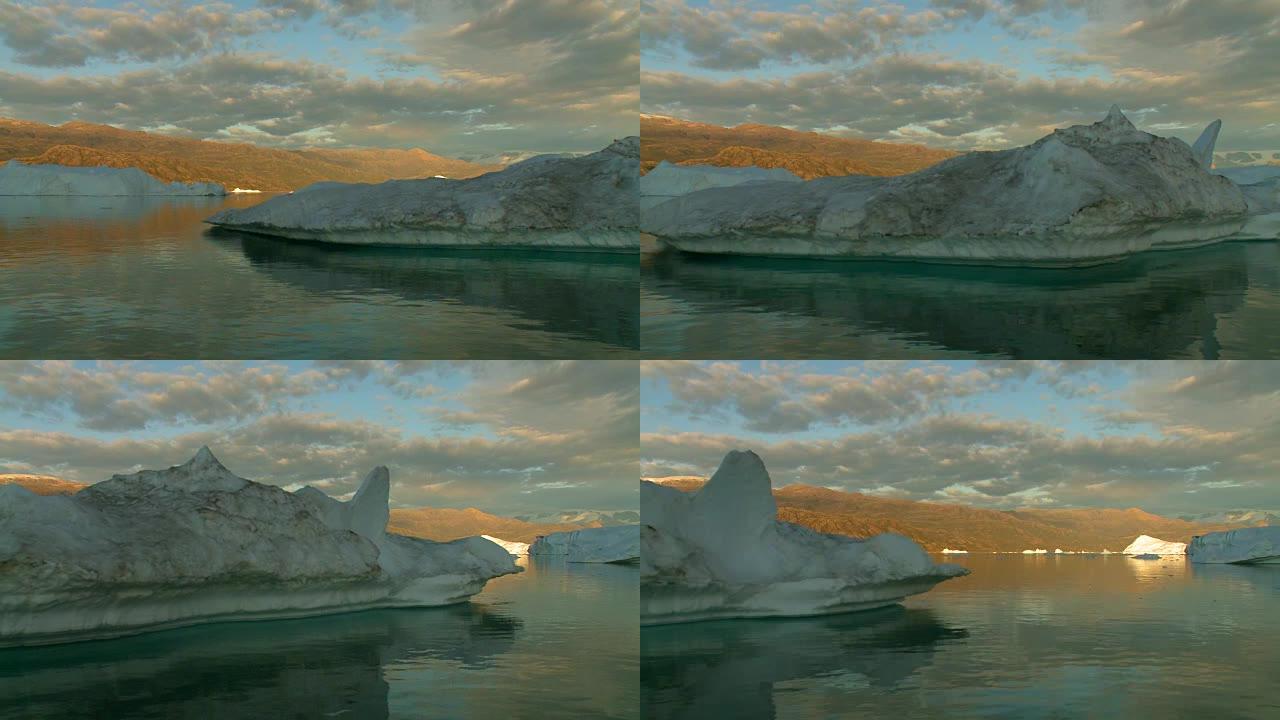 在午夜太阳格陵兰缓慢航行通过巨大的冰山