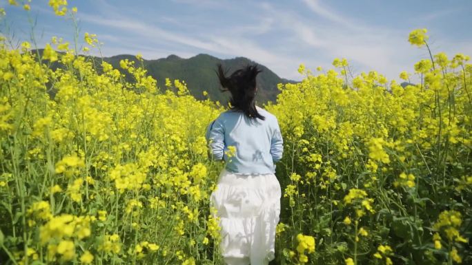 白裙美女油菜花林奔跑背影追逐梦想向往自由