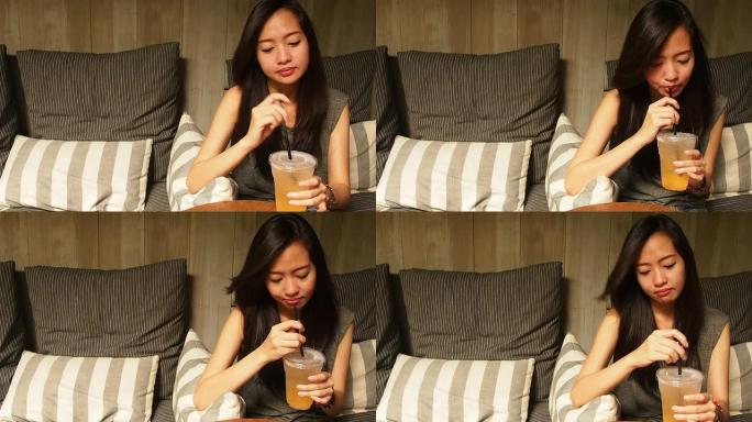 亚洲妇女喝新鲜的桃子汽水