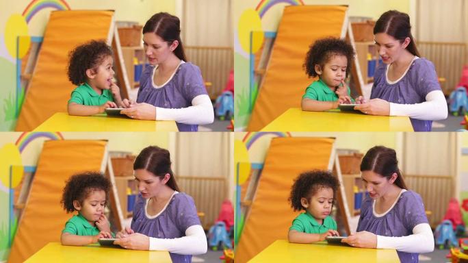幼儿园工作人员教孩子如何使用数字平板电脑