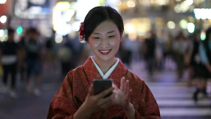 穿着和服的日本女孩在涩谷十字路口发短信