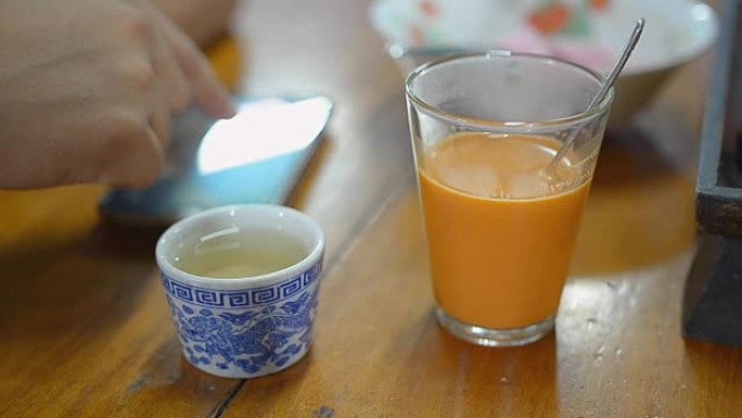 玩智能手机和搅拌奶茶