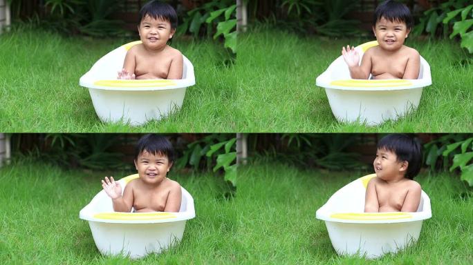 可爱的小男孩在浴缸里户外洗澡